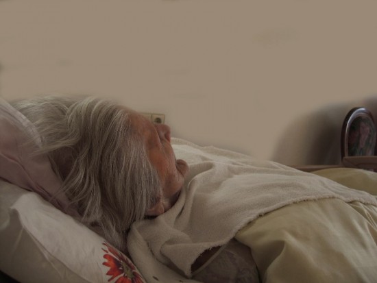 Oude vrouw in bed. Uitzichtloos en ondraaglijk lijden vormen redenen voor euthanasie.